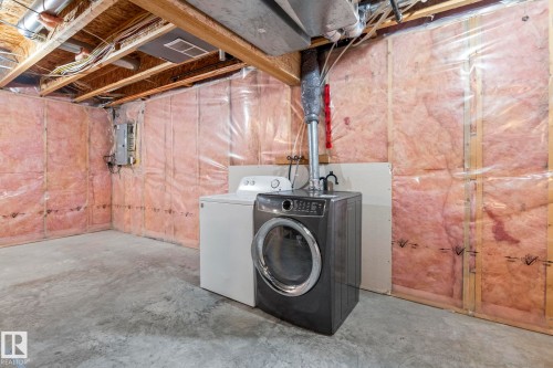 Unfinished basement space featuring exposed wood joists and concrete flooring - 7118 19A, Edmonton, AB - Indoor Photo Showing Laundry Room