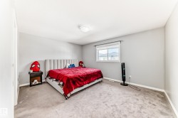 Carpeted room featuring a window with a white frame and blinds, light gray walls, white baseboards, and a flush-mount ceiling light - 