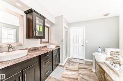 Dual vessel sinks set into a vanity with dark wood-finish cabinetry and a patterned countertop - 