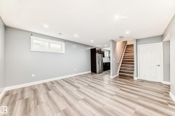 Spacious lower-level area featuring wood-finish flooring, recessed lighting, and a neutral wall palette - 