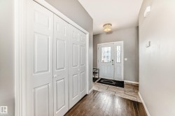 Entryway featuring a decorative front door with side light, wood-finish flooring, and a flush-mount light fixture - 