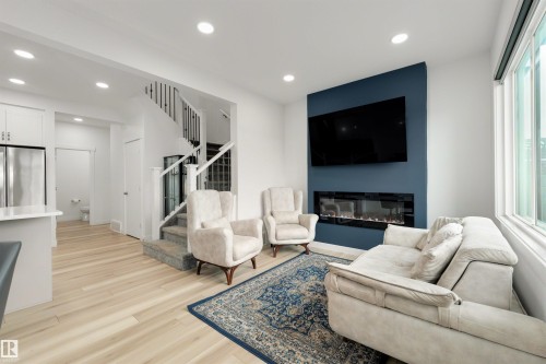 Open-concept living space with light wood-finish flooring - 3173 Checknita Way, Edmonton, AB 