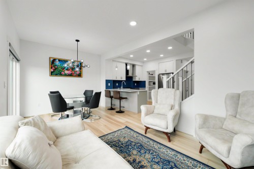 Open-concept living space featuring wood-finish flooring, recessed lighting, and a modern kitchen - 3173 Checknita Way, Edmonton, AB 
