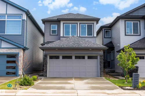 Two-story residence featuring a dark gray shingled roof and light gray siding - 3173 Checknita Way, Edmonton, AB 