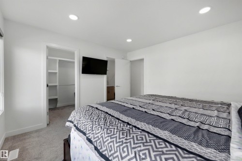 Carpeted bedroom featuring white walls, recessed lighting, and a window with a roller shade - 3173 Checknita Way, Edmonton, AB 