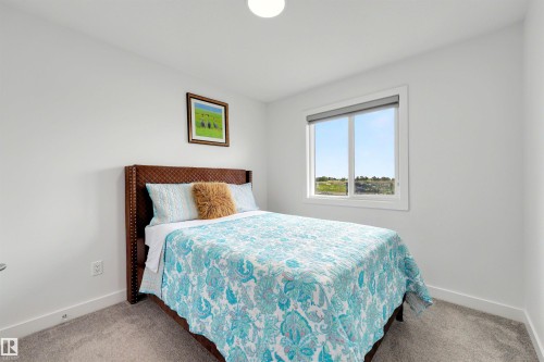 Bright bedroom featuring a single window, white trim, and light gray carpet - 3173 Checknita Way, Edmonton, AB 