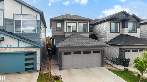 Modern two-story residence featuring a dual-tone facade with horizontal siding and stone accents - 3173 Checknita Way, Edmonton, AB 