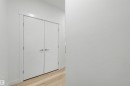 Double white doors with horizontal paneling, brushed chrome hardware, and light wood-finish flooring - 3173 Checknita Way, Edmonton, AB 