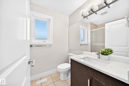 Bathroom featuring a dark wood-finish vanity with an integrated rectangular sink and a light-toned countertop - 16124 76 Street, Edmonton, AB 