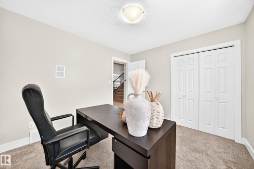 Neutral-toned room featuring a ceiling-mounted light fixture, carpeting, and white baseboards - 16124 76 Street, Edmonton, AB 