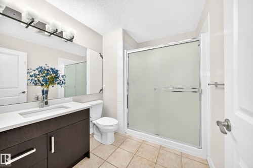 Bathroom featuring a dark wood-finish vanity with a white countertop and integrated sink - 16124 76 Street, Edmonton, AB 