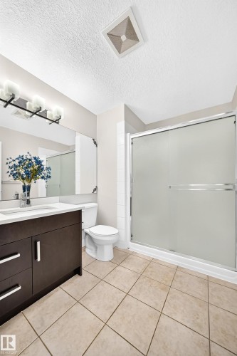 Bathroom with a dark wood-finish vanity, white countertop, and rectangular sink - 16124 76 Street, Edmonton, AB 