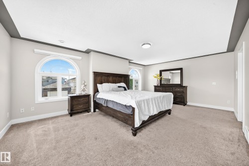 Recessed ceiling with gray trim, arched window, wall-to-wall carpeting, and light gray wall paint - 16124 76 Street, Edmonton, AB 
