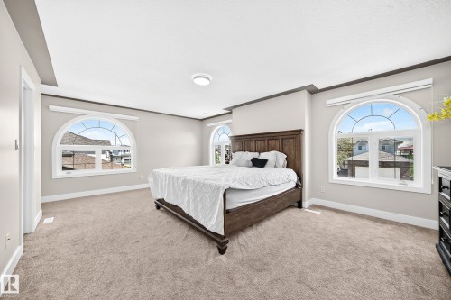 Spacious bedroom featuring light-toned carpeting and neutral wall paint - 16124 76 Street, Edmonton, AB 