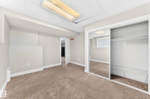 Room featuring plush carpet flooring, neutral paint palette, white baseboards, and a white ceiling - 16124 76 Street, Edmonton, AB 