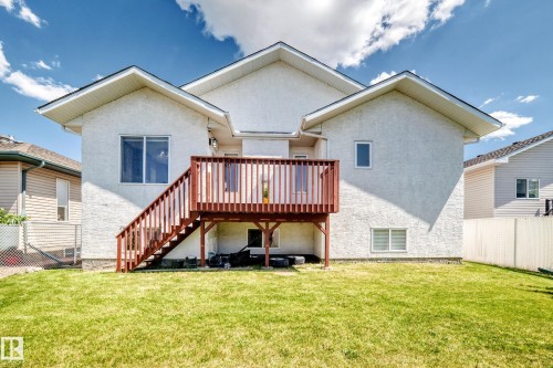 Rear exterior featuring a raised wooden deck with railings and stairs - 16124 76 Street, Edmonton, AB 