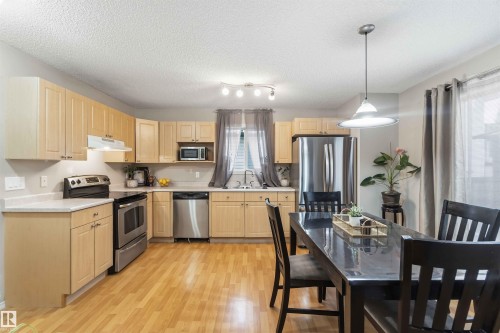 Open-concept kitchen and dining area featuring wood-finish flooring - 3117 32 Avenue, Edmonton, AB 