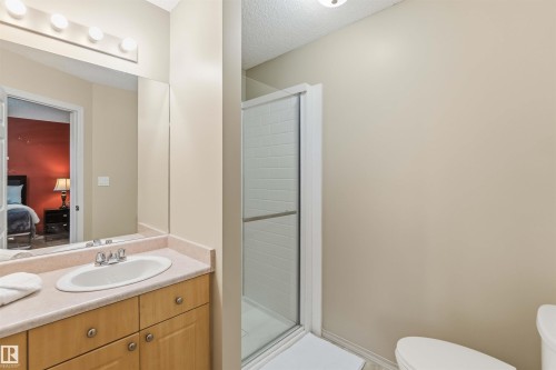 Bathroom featuring a vanity with a light wood-finish cabinet, an integrated sink, and a light-colored countertop - 3117 32 Avenue, Edmonton, AB 