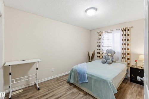 Bedroom featuring wood-finish flooring, light neutral wall paint, and a window with natural light - 3117 32 Avenue, Edmonton, AB 