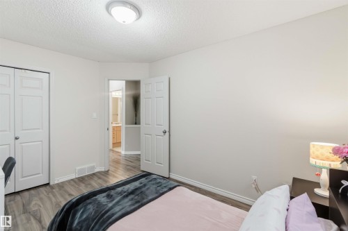 Bedroom featuring wood-finish flooring, neutral wall tones, and a ceiling-mounted light fixture - 3117 32 Avenue, Edmonton, AB 