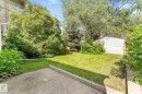 Expansive backyard featuring a lush lawn, mature trees, and a detached storage shed - 9315 86 Street, Edmonton, AB 