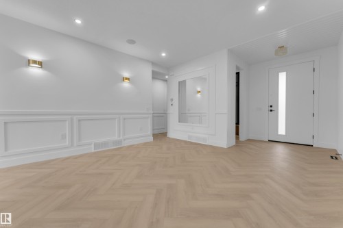 Herringbone wood-finish flooring extending from the entry - 7677 Kimiwan Crescent, Edmonton, AB 