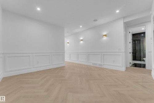 Herringbone wood-finish flooring complements white wainscoting and wall sconces - 7677 Kimiwan Crescent, Edmonton, AB 