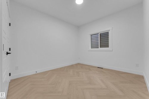 Bright interior space featuring light wood-finish flooring in a herringbone pattern - 7677 Kimiwan Crescent, Edmonton, AB 