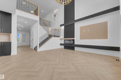 Open-concept living space featuring light wood-finish flooring in a herringbone pattern - 7677 Kimiwan Crescent, Edmonton, AB 