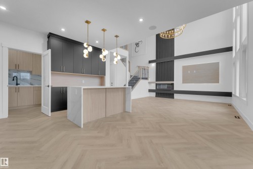 Open-concept living space with herringbone wood-finish flooring - 7677 Kimiwan Crescent, Edmonton, AB 
