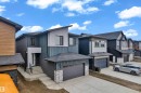 Modern multi-level residence featuring a contrasting exterior of vertical blue siding and white stucco accents - 7677 Kimiwan Crescent, Edmonton, AB 