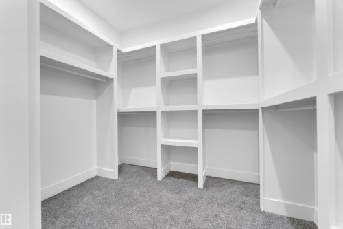 Custom-built closet system featuring white shelving and hanging rods - 7677 Kimiwan Crescent, Edmonton, AB 