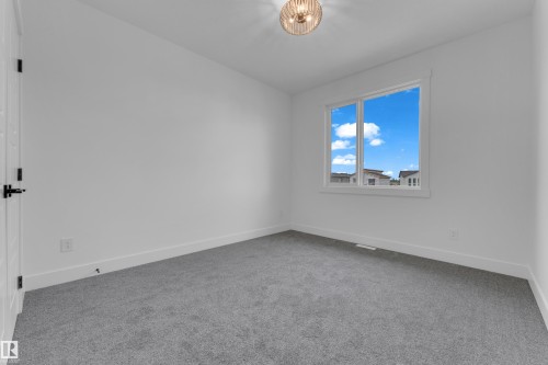 Room featuring light gray carpeting, white walls, and a single window with white trim - 7677 Kimiwan Crescent, Edmonton, AB 