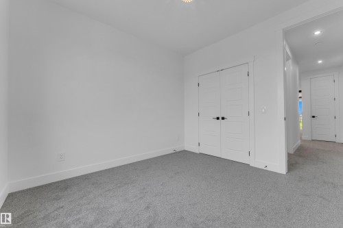 Neutral-toned room featuring light gray carpeting and white walls - 7677 Kimiwan Crescent, Edmonton, AB 