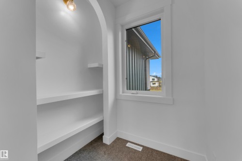 Recessed shelving with an arched entryway features an overhead light fixture - 7677 Kimiwan Crescent, Edmonton, AB 
