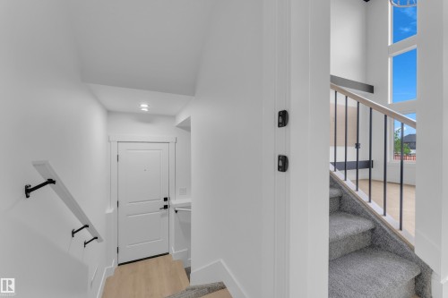Entryway with light wood-finish flooring and a white paneled door - 7677 Kimiwan Crescent, Edmonton, AB 