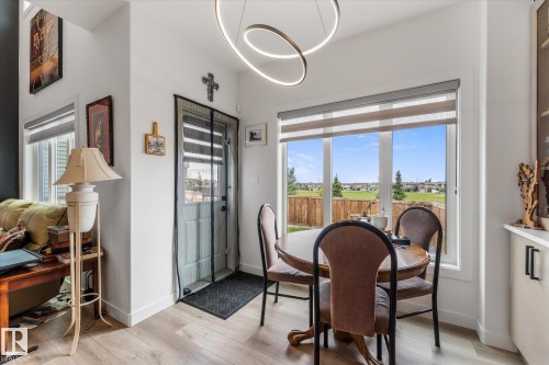 Dining area featuring a large window overlooking a landscaped green space - 94 Elm Street, Fort Saskatchewan, AB 