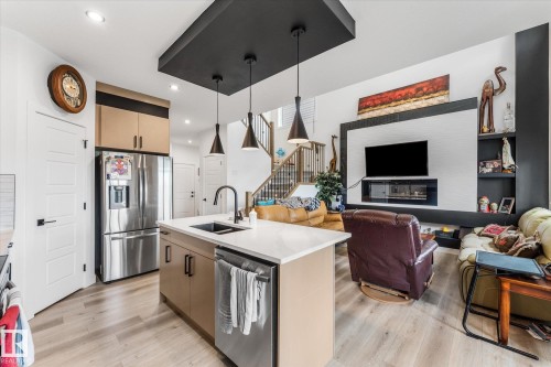 Open-concept living area with light wood-finish flooring - 94 Elm Street, Fort Saskatchewan, AB 