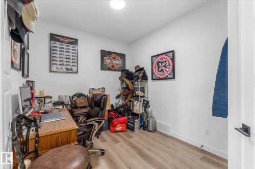 Versatile room featuring light wood-finish flooring, white painted walls, and a recessed ceiling light - 94 Elm Street, Fort Saskatchewan, AB 