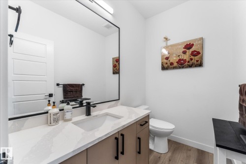 Contemporary vanity featuring a rectangular undermount sink set into a light-toned countertop, paired with matte black fixtures - 94 Elm Street, Fort Saskatchewan, AB 