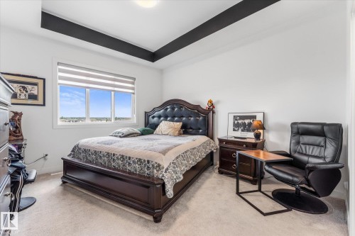 White-painted room featuring a tray ceiling with dark accent beams - 94 Elm Street, Fort Saskatchewan, AB 