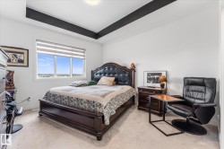 White-painted room featuring a tray ceiling with dark accent beams - 