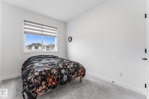 Interior room featuring light gray carpeting, white baseboards, and a white window frame - 94 Elm Street, Fort Saskatchewan, AB 