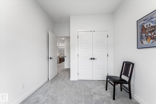 Interior room featuring light gray carpeting and white walls - 94 Elm Street, Fort Saskatchewan, AB 