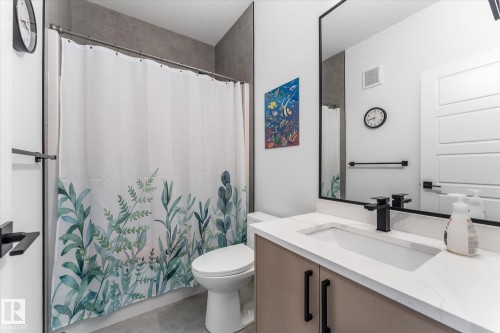 Bathroom featuring a single vanity with a white countertop and integrated sink - 94 Elm Street, Fort Saskatchewan, AB 