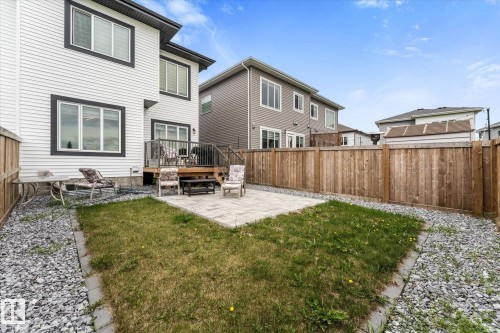 Expansive backyard featuring a wood deck, a paved patio, and a grass lawn - 94 Elm Street, Fort Saskatchewan, AB 