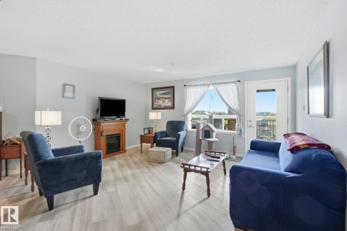 Bright living area featuring light wood-finish flooring - 1223 9363 Simpson Dr, Edmonton, AB 