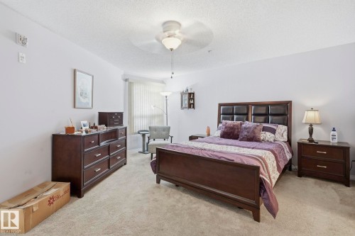 Spacious room featuring neutral carpeting, light-colored walls, and a ceiling fan with integrated lighting - 1223 9363 Simpson Dr, Edmonton, AB 