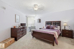 Spacious room featuring neutral carpeting, light-colored walls, and a ceiling fan with integrated lighting - 