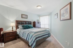 Carpeted bedroom featuring light blue walls and a window with vertical blinds - 